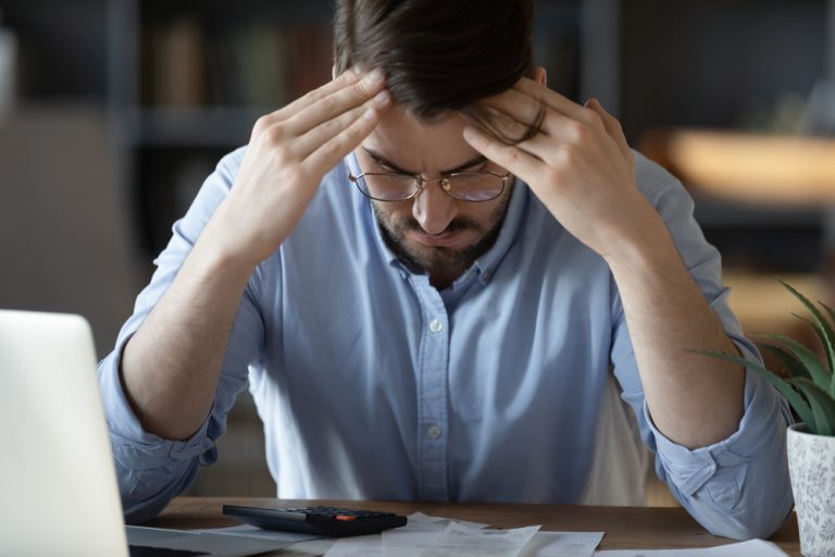 35s,businessman,sitting,at,workplace,desk,with,bowed,head,,on