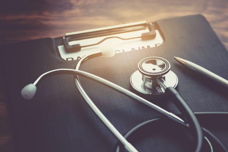 Health,insurance,claim,form,with,stethoscope,on,wood,table,selective