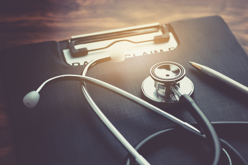 Health,insurance,claim,form,with,stethoscope,on,wood,table,selective